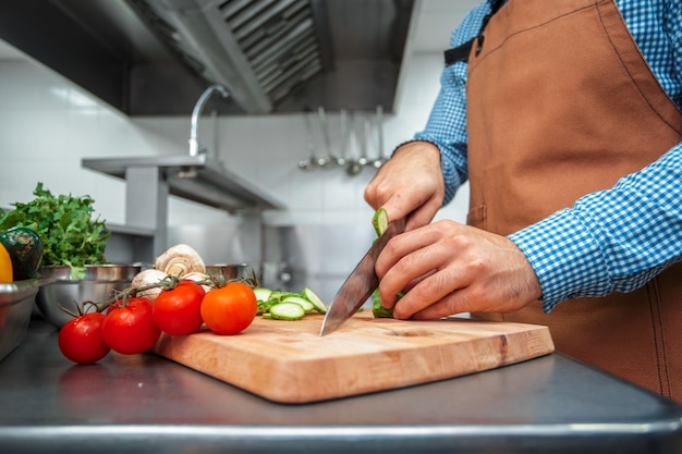 The chef in brown apron cooking in a restaurant kitchen