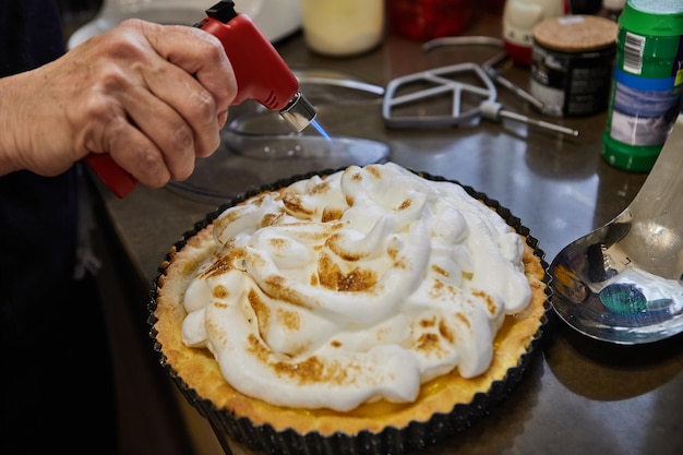 Шеф-повар поджигает сливки на пироге из пассифлоры Французская кухня для гурманов