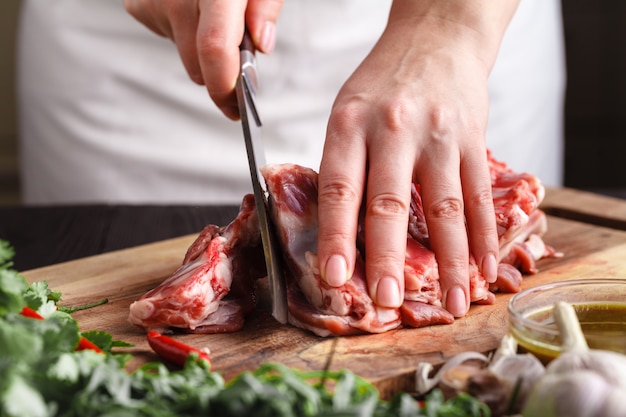 Lo chef macellaio taglio di carne di agnello con coltello