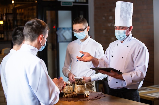 The chef conducts a briefing of employees in the restaurant