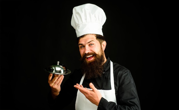 Chef cook holds metallic dish serving and presentation cook holds cloche in restaurant cooking