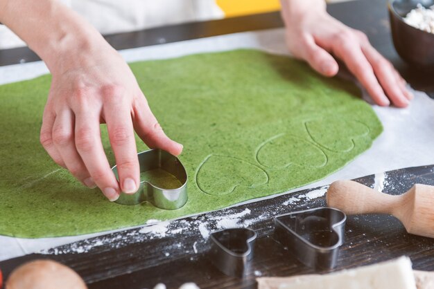 Chef cook step by step makes green ravioli in the shape of a heart for a festive dinner