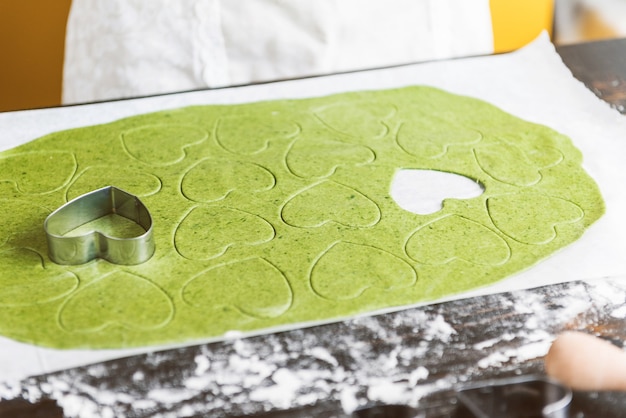 シェフの料理人が一歩一歩、お祝いのディナーのためにハートの形をした緑のラビオリを作ります