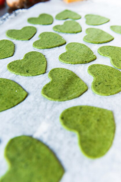 Lo chef cuoco passo dopo passo prepara i ravioli verdi a forma di cuore per una cena festiva