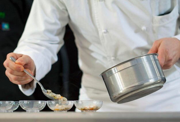 Chef cooking in cups in a restaurant kitchen