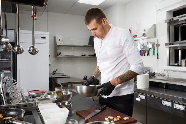 Chef cooking in the modern kitchen in hotel restaurant preparing shrimp salad