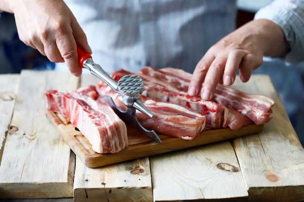 A chef cooking raw pork ribs