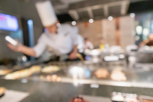 Chef cooking in restaurant kitchen blurred defocused background