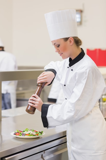 Chef cooking a salad with pepper