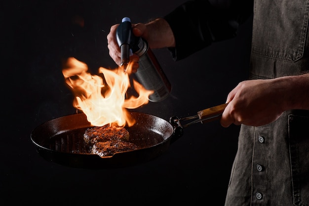 Chef cooks burgers, roasts meatballs on open fire