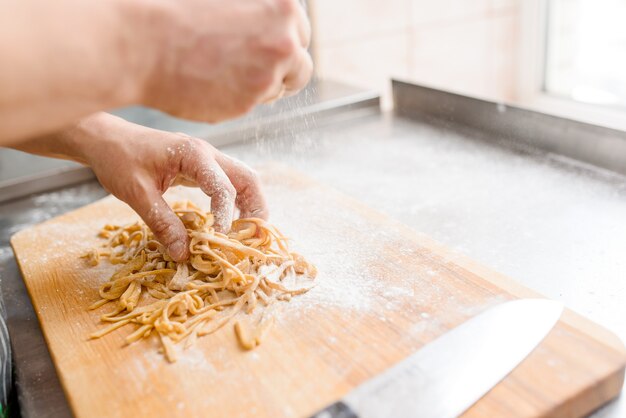 ラーメンスープに小麦粉を使って生麺を調理するシェフ