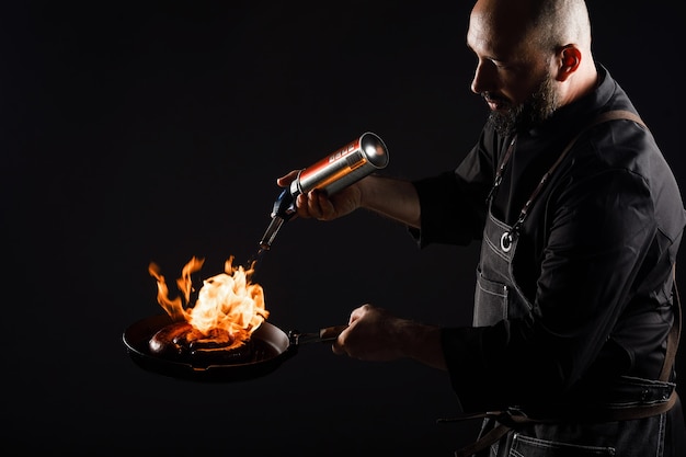 Chef cooks sausage, roasts meatballs on open fire