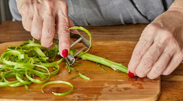 Lo chef taglia gli asparagi a fettine sottili per preparare il piatto