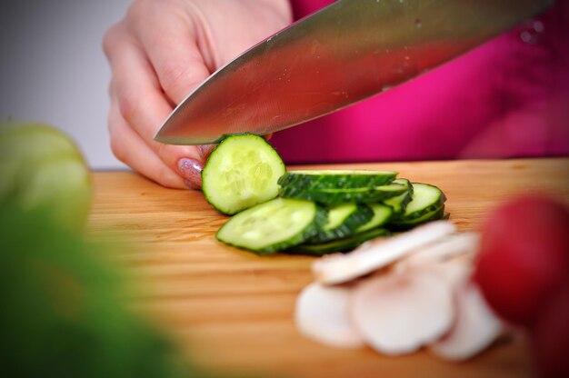 Photo chef cuts cucumber