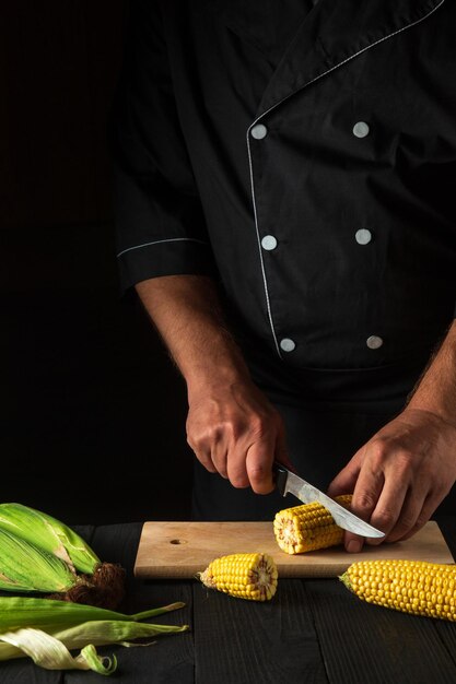 The chef cuts fresh corn with a knife Boiled corn is a great diet for breakfast or lunch