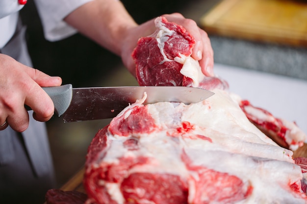 Chef cuts meat with a knife in a restaurant