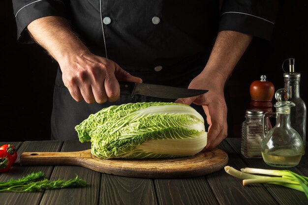 The chef cuts Peking cabbage with a knife