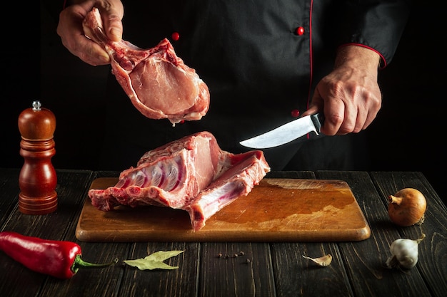 The chef cuts raw ribs on a cutting board before baking European cuisine Cooking delicious food in the kitchen