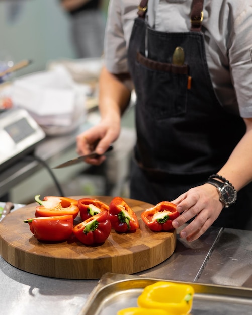 Foto lo chef taglia il peperone rosso