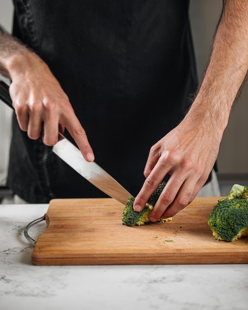 Chef cutting broccoli preparing meal