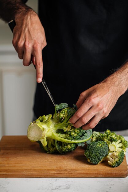 Foto chef che taglia i broccoli e prepara il pasto