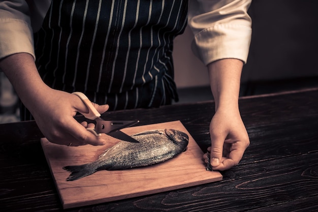 Chef cutting the fish on a board