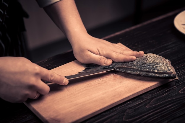 Chef cutting the fish on a board