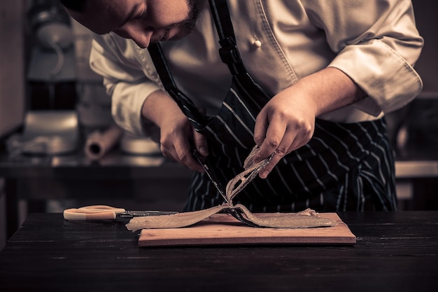 Chef cutting the fish on a board