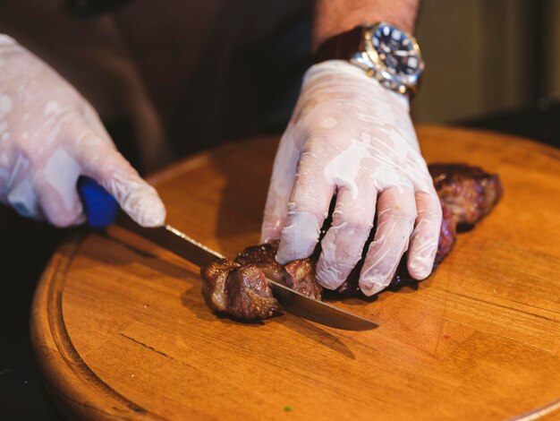 A chef cutting meat in the kitchen