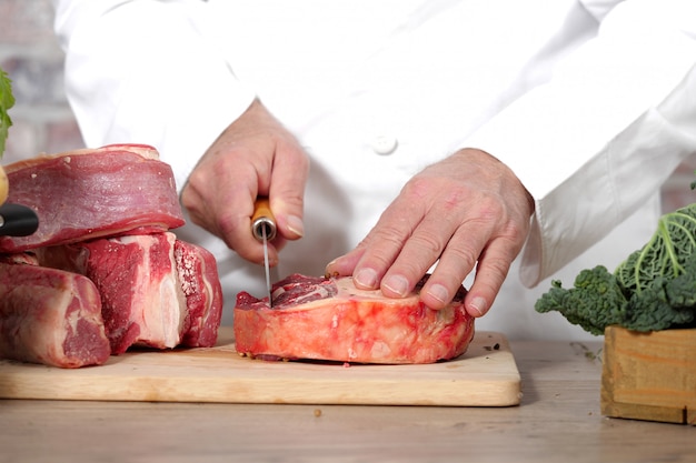 Chef cutting the meat on a wooden board