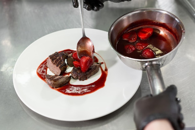 Chef decorates the meat with strawberries