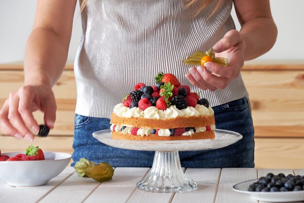 Cuoco unico che decora la torta frutti di bosco