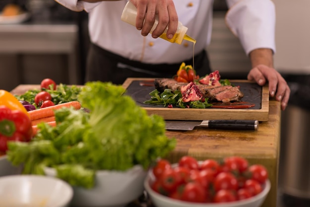 Chef finishing steak meat plate with Finally dish dressing and almost ready to serve at the table