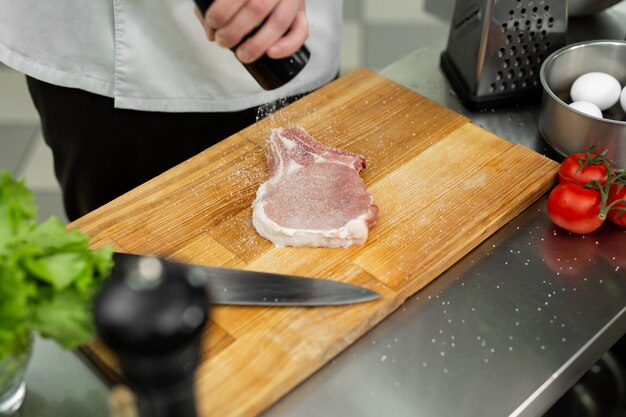 Chef giet zout op rundvlees met zoutvaatje Barbecue