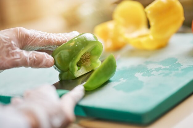 Chef in gloves cutting and preparing vegetables