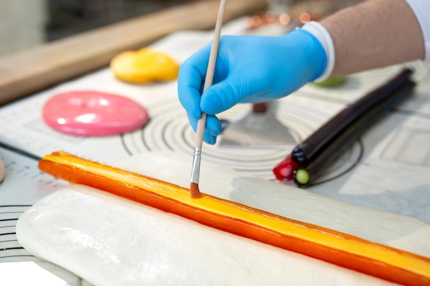 Chef glues multi colored pieces of hot caramel and lollipops Candy Handmade