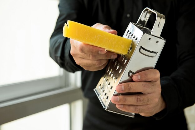 Chef grating Italian parmesan cheese 