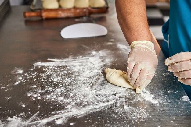 Chef hands prepares apple pies in the restaurant kitchen. The process of making sweet buns. Raw dough for baking in the oven.