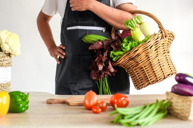 シェフの手が台所のテーブルで野菜を準備し、調理する準備ができています