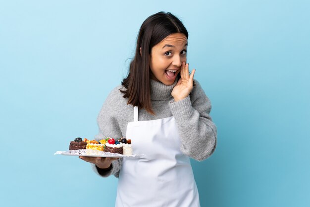 chef holding a big cake pointing to the side to present a product and whispering something