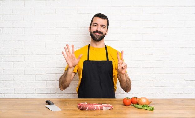 Chef holding in a cuisine counting seven with fingers