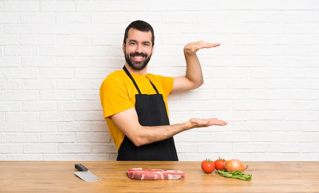 Chef holding in a cuisine holding copyspace to insert an ad