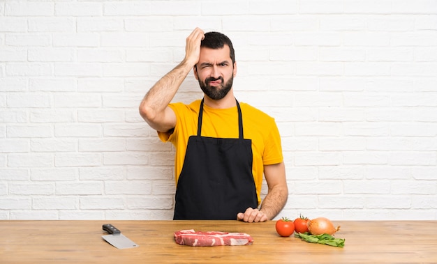 Chef holding in a cuisine with an expression of frustration and not understanding