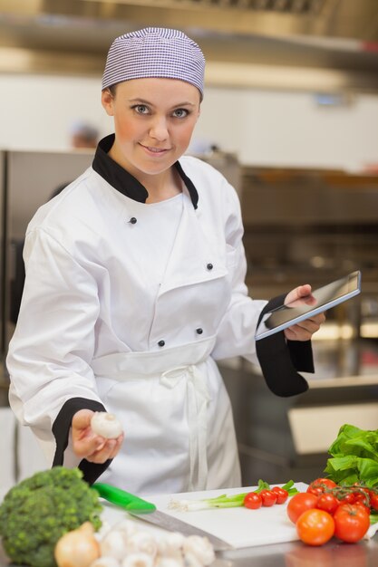 Chef holding digital tablet and mushroom 