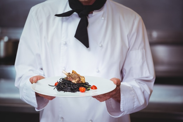 Chef holding a dish with spaghetti