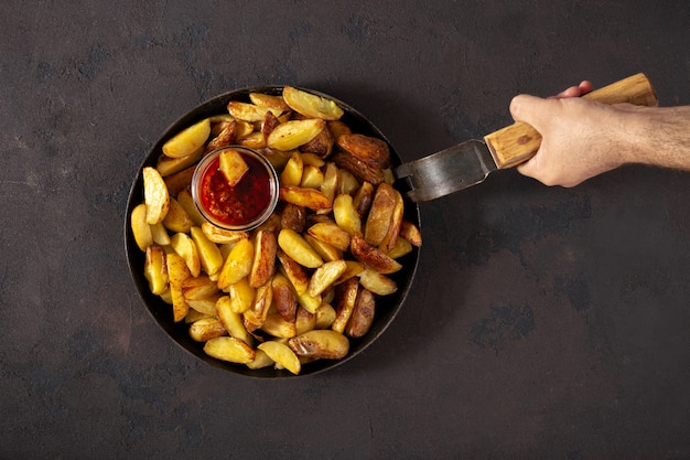 Chef holding pan with fresh fried potatoes