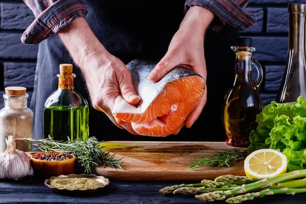 Chef holding a piece of raw salmon fish