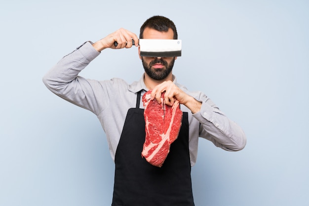 Chef holding a raw meat covering his eyes