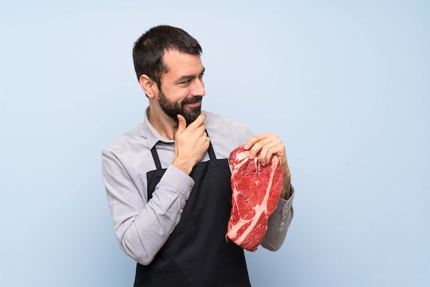 Chef holding a raw meat looking to the side