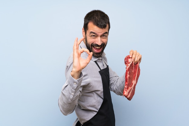 Chef holding a raw meat showing ok sign and thumb up gesture